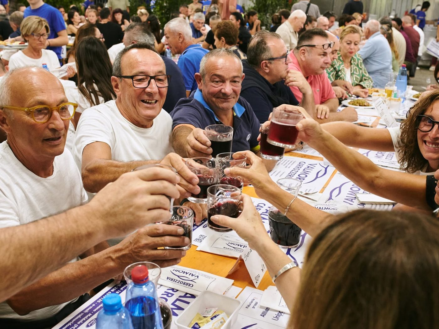 Brindisi con il vino di Romagna al tavolo della sagra